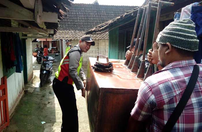 Petugas saat membawa barang bukti berupa alat yang dipakai produksi arak. 