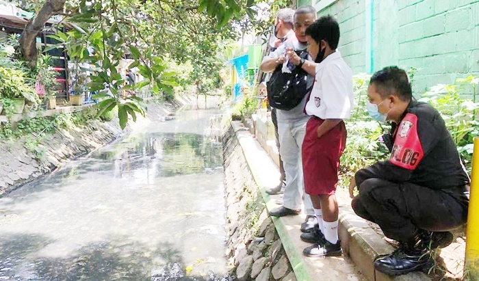 Rafli sedang menunjukkan lokasi temuannya yang diduga janin di selokan.