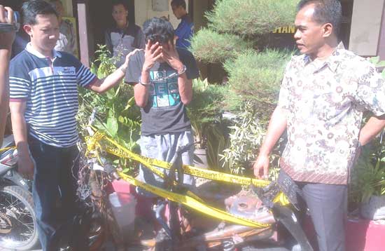 Satu dari dua pejambret dan motor yang dibakar warga. (foto: rusmiyanto/BANGSAONLINE) 