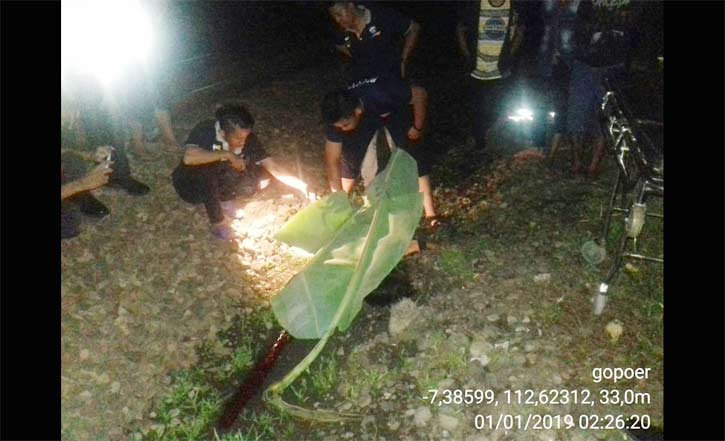 Jenazah korban diperiksa petugas sebelum dievakuasi.
