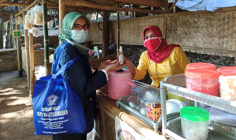 Sapa Pedagang Bring Raharjo, Mahasiswa KKN Unair Bagikan Masker dan Hand Sanitizer