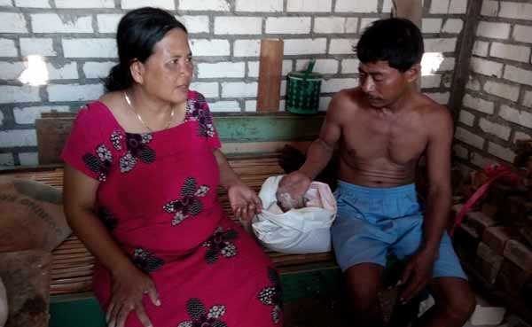 Pujiati bersama suaminya saat menunjukkan raskin yang berkutu dan bubukan. foto: suwandi/BANGSAONLINE