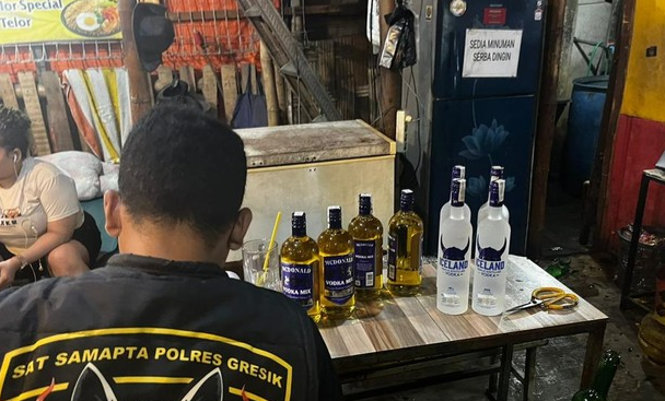 Polisi saat menindak temuan ratusan botol miras yang ditemukan di warung kawasan pelabuhan Gresik