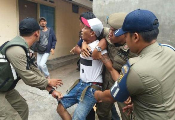?Tersangka saat berusaha melarikan diri saat diamankan petugas Satpol PP Kota Kediri. Foto: ARIF K/BANGSAONLINE
