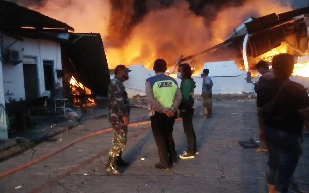 Tampak api melalap bangunan pabrik sepatu dan sandal di Jalan Raya Kundi, Desa Kepuh Kiriman, Kecamatan Waru, Sidoarjo.