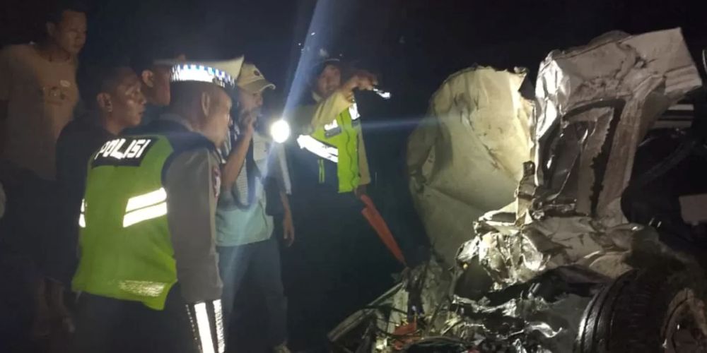 Petugas saat mengidentifikasi mobil yang ringsek usai mengalami laka dengan KA Sembrani