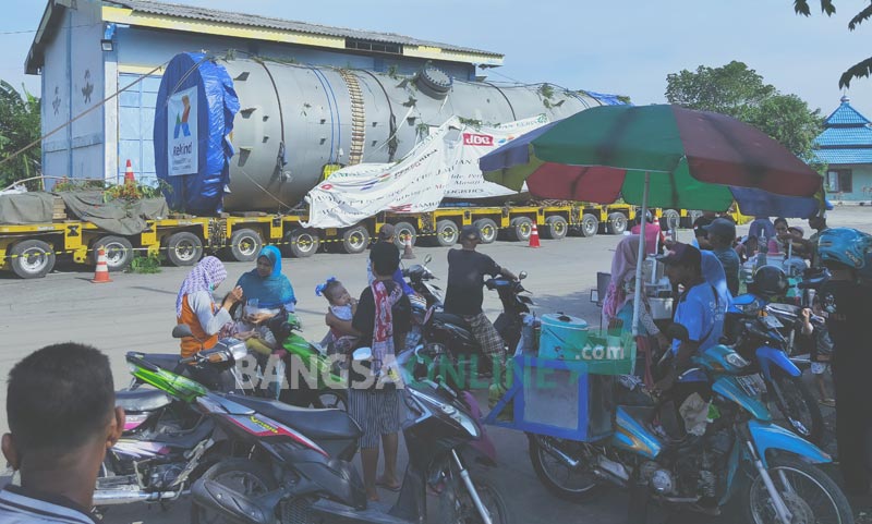 Tampak sejumlah PKL dadakan memenuhi Jembatan Timbang Desa Sraturejo, Kecamatan Baureno, lokasi parkir multi axle truk trailer yang mengangkut Absorber Section #1 trip 1 untuk proyek Lapangan Unitisasi Gas Jambaran - Tiung Biru (J-TB).