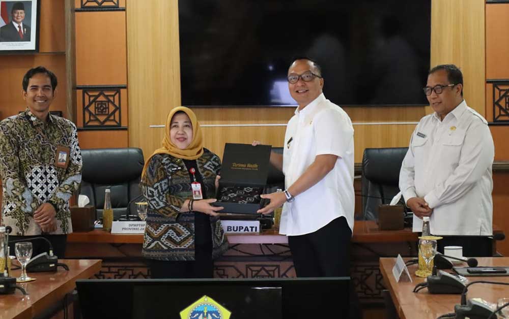 Plt Bupati Gresik, Asluchul Alif memberikan cenderamata kepada Kepala DPMPTSP Provinsi Jawa Timur, Dyah Wahyu Ermawati. Foto: Ist.
