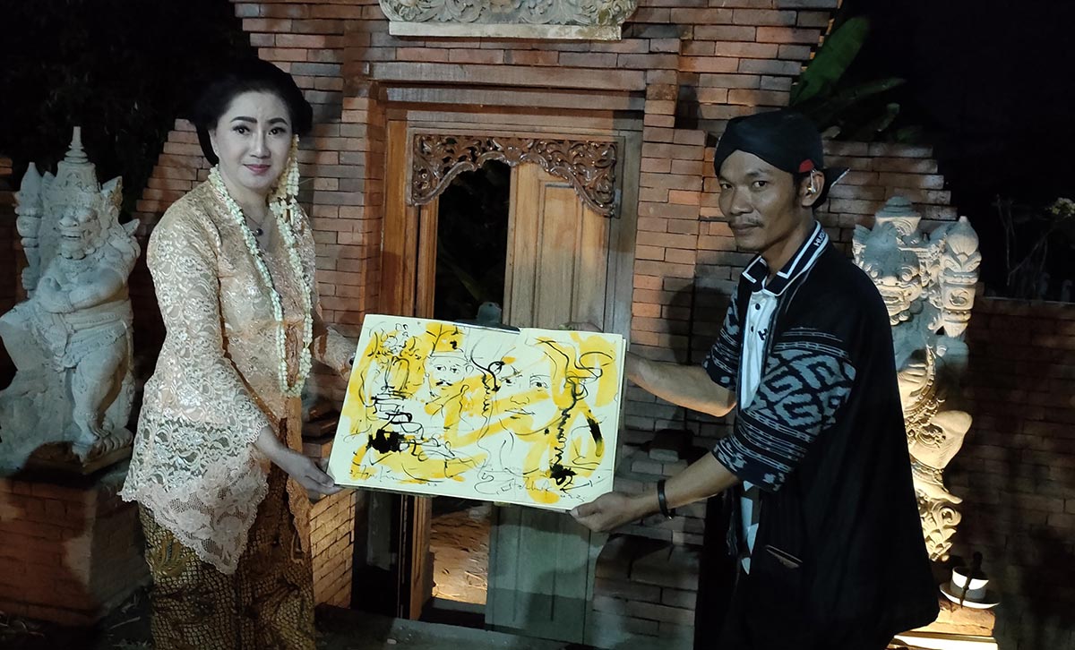 Fathurrohman saat menyerahkan hasil sketsanya kepada seorang perempuan yang masih ada hubungan kekerabatan dengan tokoh di era Mataram. Foto: MUJI HARJITA/ BANGSAONLINE