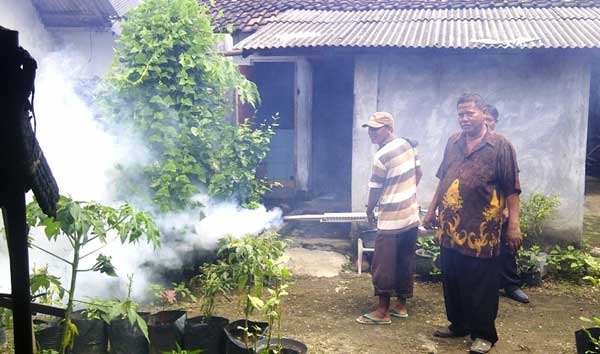 Warga Desa Cerme saat memberikan pelayanan penyemprotan ke rumah warga. foto: soewandito/ BANGSAONLINE