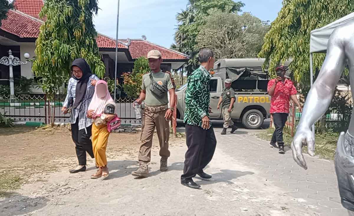 Petugas dari Satpol PP Pamekasan saat mengamankan bocah yang disuruh ibunya untuk mencari nafkah dengan mengamen.
