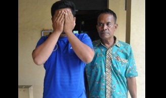 Tersangka Achmad Mudakir didampingi petugas Polsek Porong, kemarin. Foto: Agus HP/BANGSAONLINE