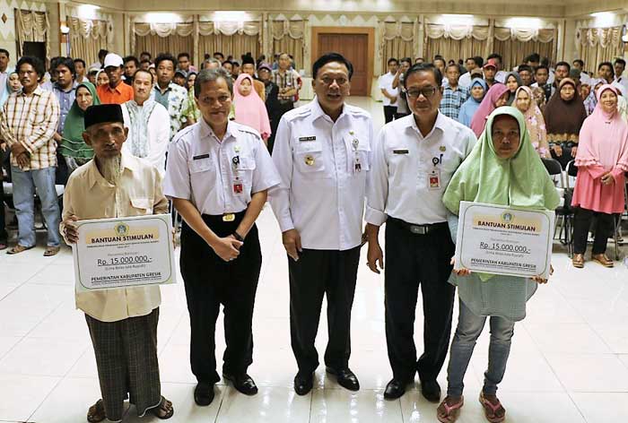 Bupati Sambari didampingi Sekkab Kng. Djoko Sulistio Hadi saat penyerahan bantuan stimulan perbaikan rumah tak layak. foto: SYUHUD/ BANGSAONLINE