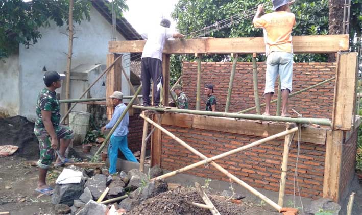 Warga bersama Satgas TMMD Jember saat membangun pos siskamling.