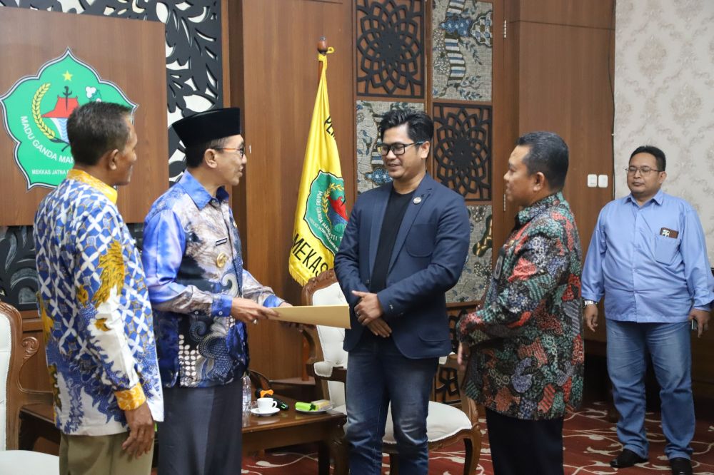  Bupati Pamekasan Kholilurrahman (dua dari kiri) saat menerima laporan pengembalian dana yang diserahkan langsung oleh Komisioner Divisi Teknis Penyelenggara KPU Pamekasan, A. Tajul Arifin.