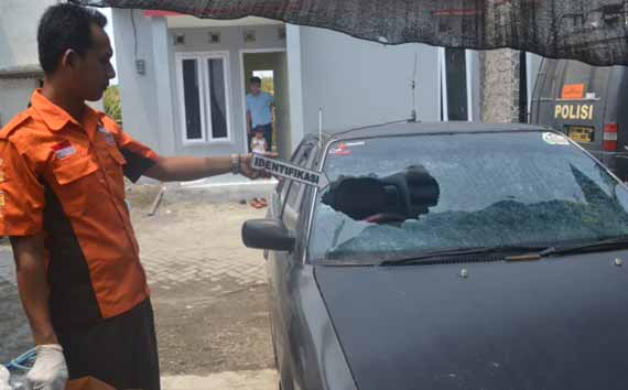Petugas kepolisian saat melakukan olah TKP pecah kaca mobil milik pemantau Pilkada. foto: dendi martoni/BANGSAONLINE