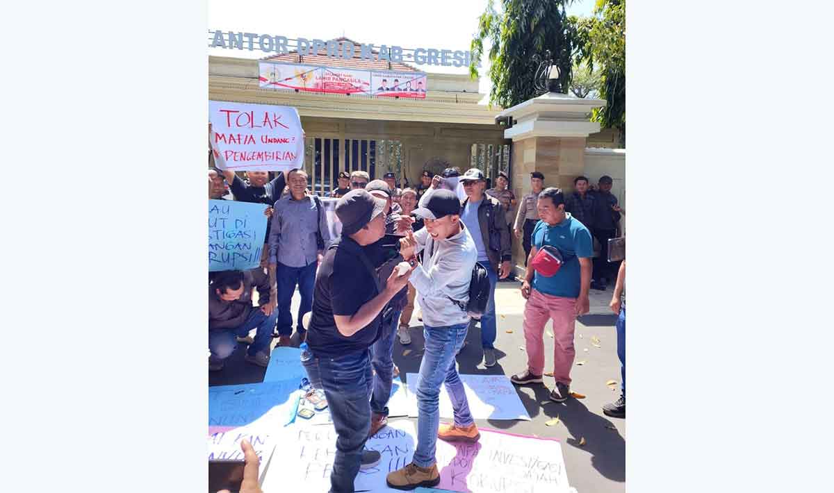 Aksi teatrikal adegan pengereyokan yang diperagakan Wartawan BANGSAONLINE, M. Syuhud Almanfaluty (kanan), dan wartawan MemoX, M. Sugeng, saat demo penolakan RUU Penyiaran di DPRD Gresik. Foto: Ist