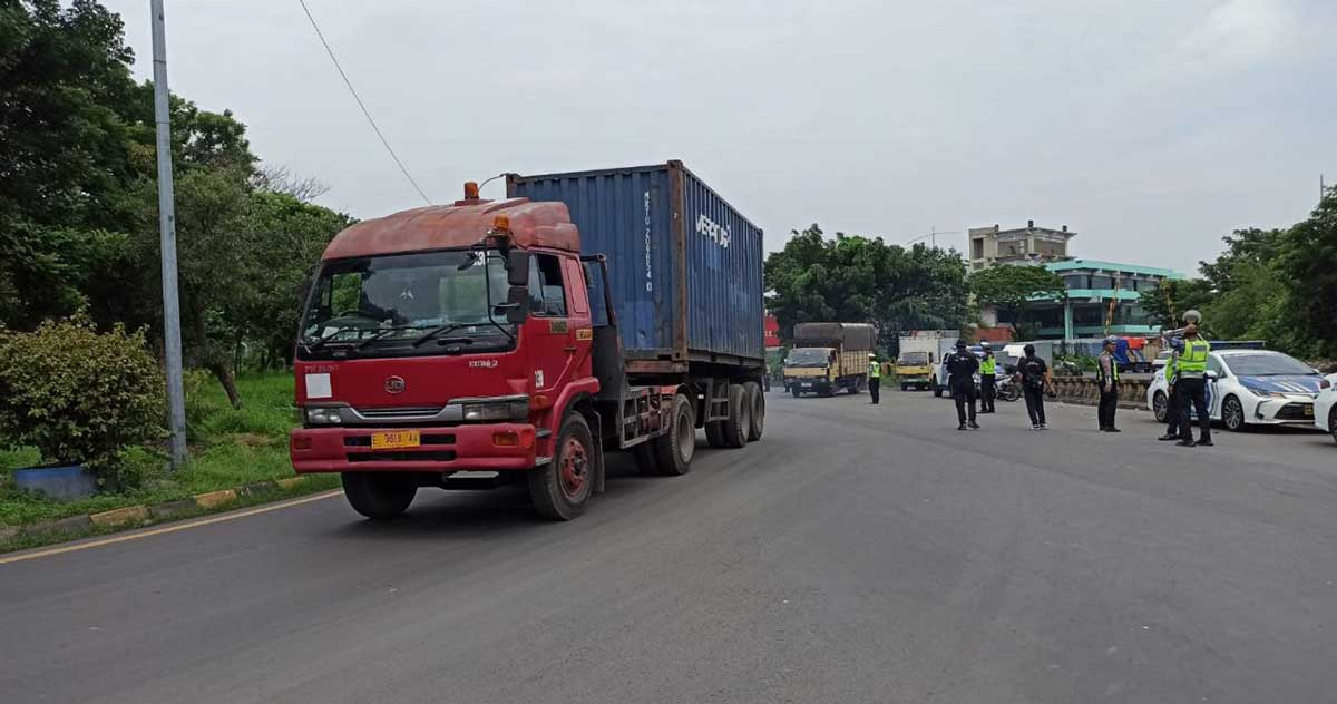 Petugas saat memeriksa truk pengangkut barang.