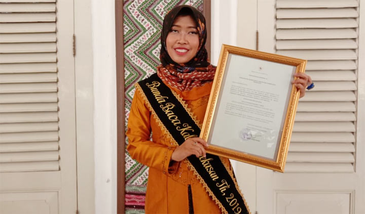 Nayla Baddrut Tamam menunjukkan penghargaan Bunda Baca Kabupaten Pamekasan 2019.