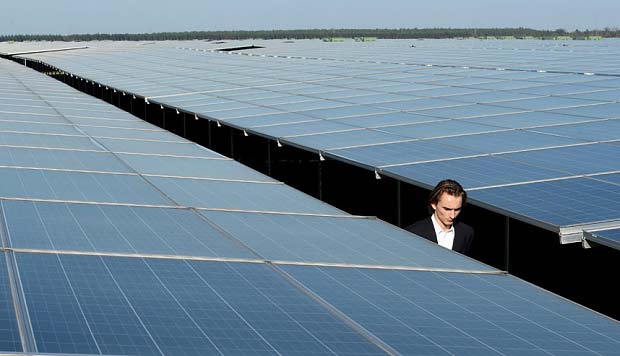 Seorang pria berjalan antara panel Photovoltaic di pusat Energi Matahari, yang baru saja diresmikan 1 Desember 2015, di Cestas kemarin. foto: telegraph.co.uk/AFP/Getty Images