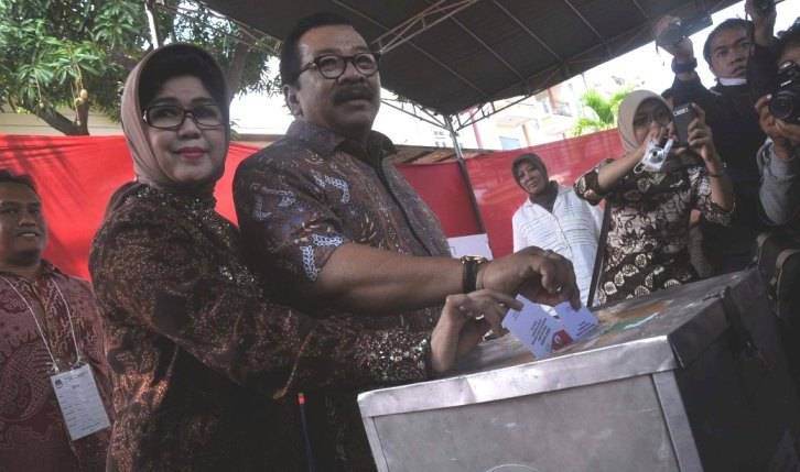 Gubernur Jatim Soekarwo dan isterinya Nina Kirana memasukkan kertas suara Pilpres di kotak suara TPS 27 Kelurahan Manyar Sabrangan Kecamatan Mulyorejo, Surabaya. foto :  nisa/BangsaOnline
 