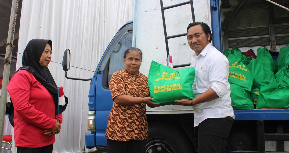 Petugas dari Dinkes Kabupaten Kediri saat menyerahkan bantuan secara simbolis kepada salah seorang warga. Foto: Ist