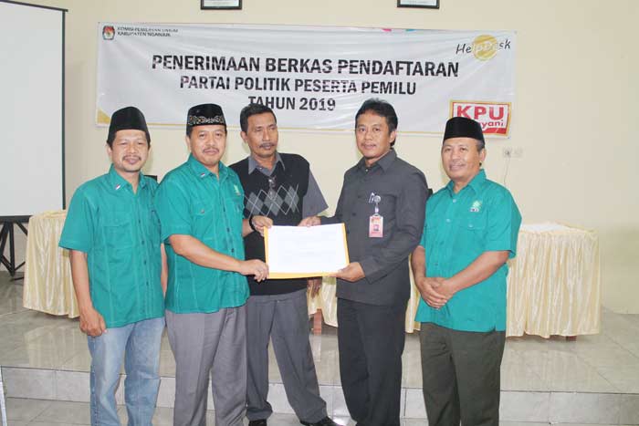 Ketua DPC PKB Nganjuk Ulum Bastomi saat menerima bukti tanda terima berkas pendaftrana dari Komisioner KPU Nganjuk Divisi Hukum Yudha Hernanto (dua dari kanan). Foto: BAMBANG D J/BANGSAONLINE