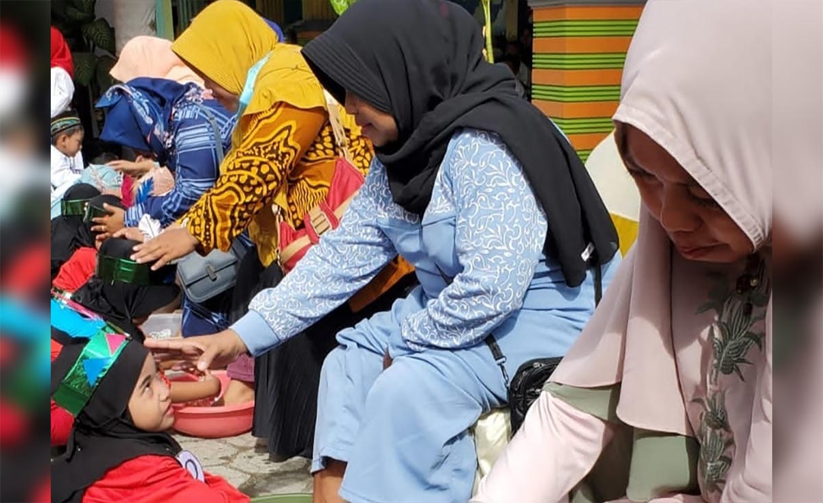 Siswa PAUD At-Tin saat membasuh kaki ibunya. Foto: AAN AMRULLOH/ BANGSAONLINE