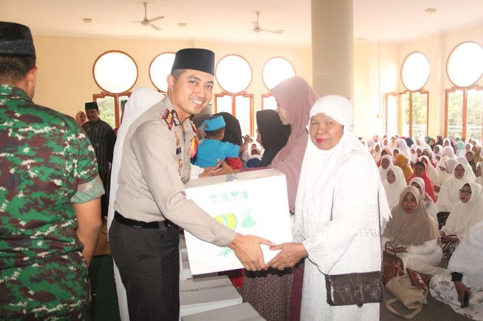 Kapolres AKPB Wahyu Sri Bintoro saat memberikan bingkisan kepada anak yatim piatu dan janda.  foto: SYUHUD/ BANGSAONLINE