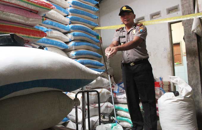 Petugas kepolisian saat menunjukkan beras polesan berpemutih di sebuah gudang di Desa Tepas Kecamatan Kesamben.