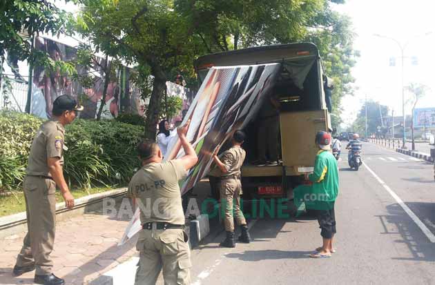 Reklame raksasa bertuliskan Gunawangsa di Jalan Raya Veteran Kebomas saat diturunkan. foto: SYUHUD/ BANGSAONLINE