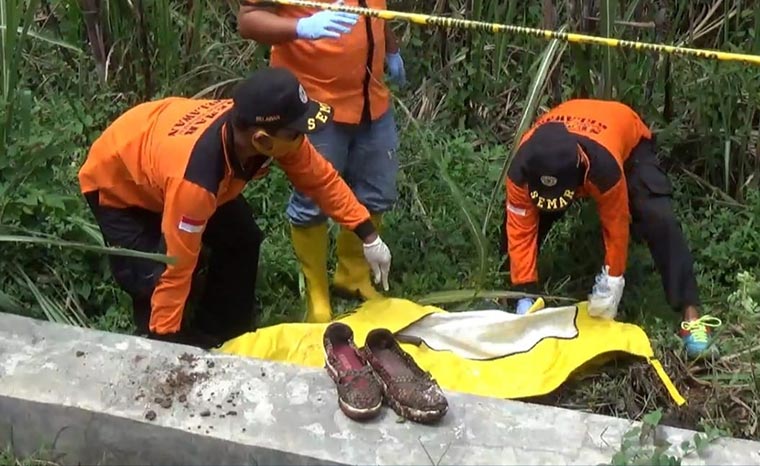 Petugas saat mengevakuasi jenazah korban.