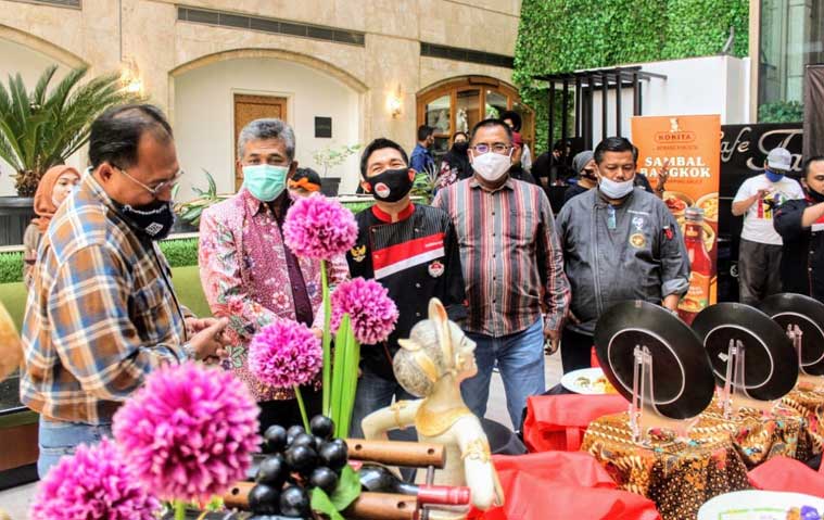 Sinarto, S.Kr., M.M. (pakai masker hijau toska), Kepala Dinas Kebudayaan dan Pariwisata (Kadisbudpar) Provinsi Jawa Timur saat melihat kreasi plating peserta didampingi Firman S. Permana, General Manager (GM) Surabaya Suite Hotel, Sabtu (26/9). foto: nanang fachrurozi/ bangsaonline.com