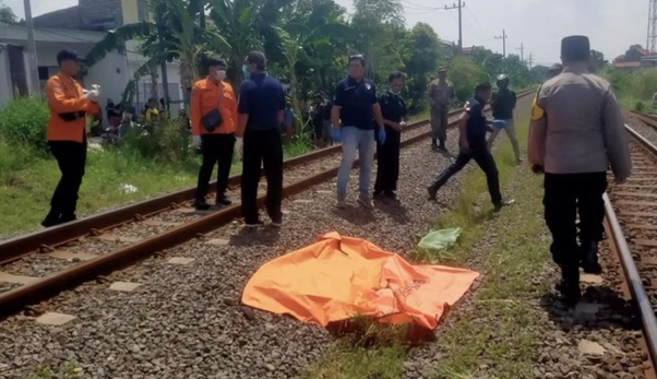 Petugas saat akan mengevakuasi lansia yang tertabrak KA Gumarang