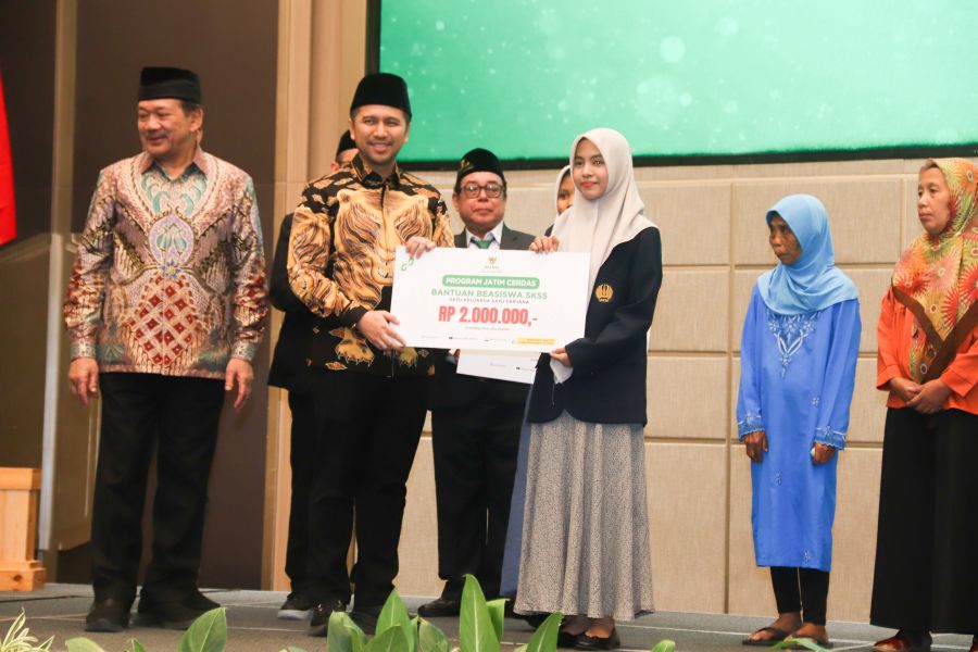 Ketua Baznas Jatim KH Ali Maschan Moesa saat menyerahkan beasiswa program SKSS kepada seorang siswi saat rakorda. Foto: YUDI A/BANGSAONLINE