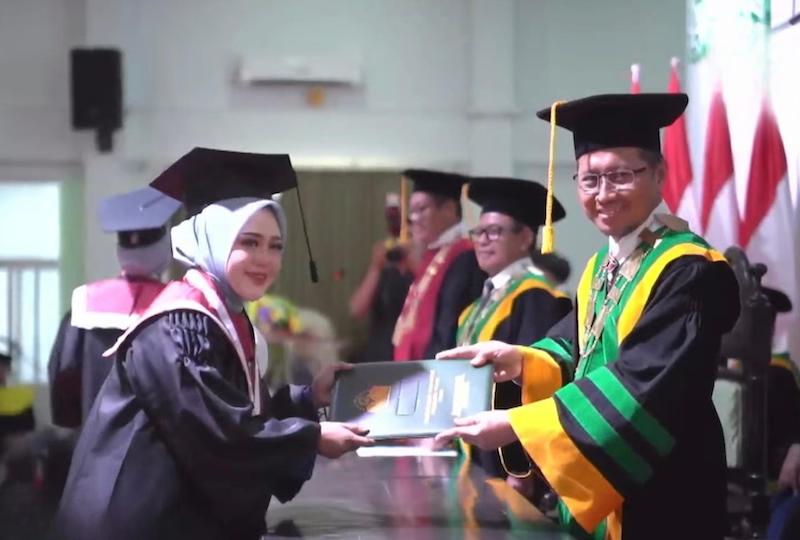 Rektor IIKNU Tuban, Miftahul Munir saat mewisuda salah seorang mahasiswi di prosesi wisuda ke VII