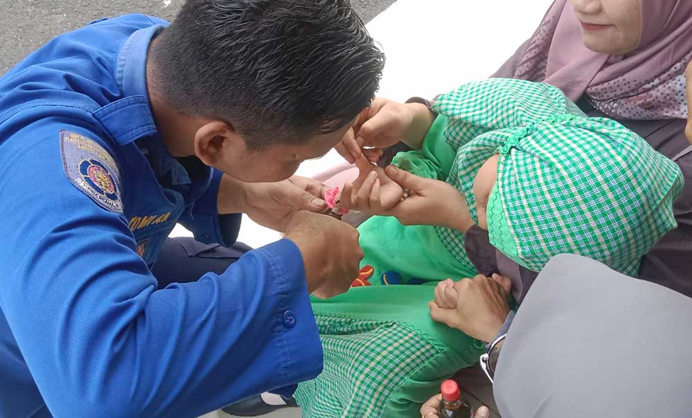 Petugas Damkar Tuban ketika mengevakuasi permainan lego yang tersangkut di jari tangan seorang bocah.