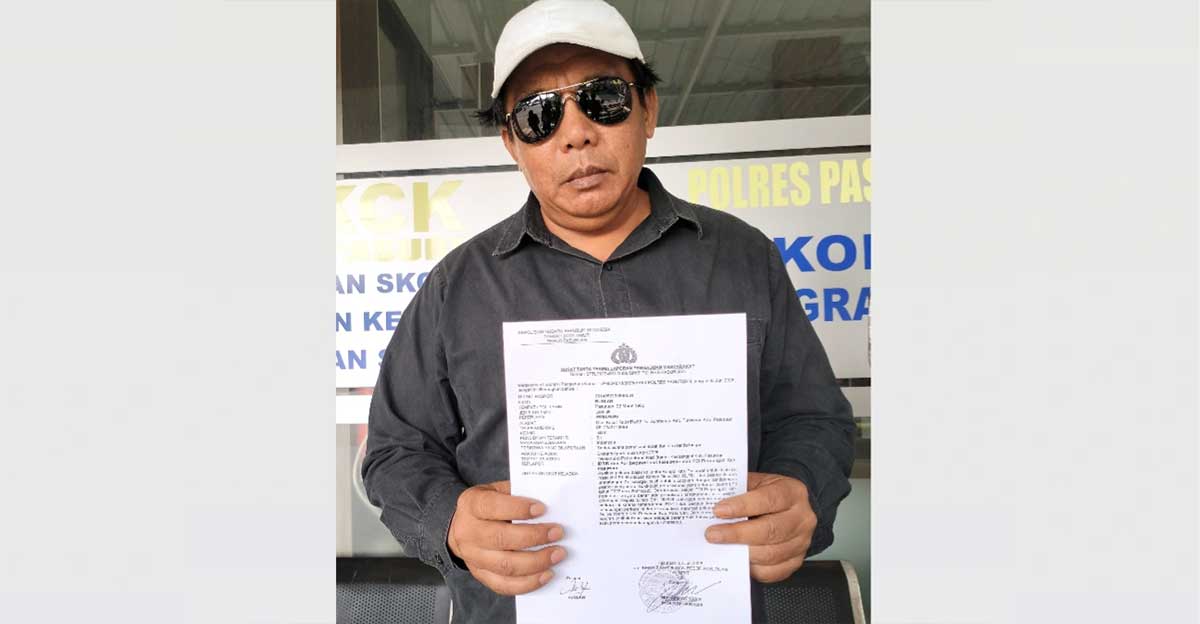 Kader PDIP di Kabupaten Pasuruan, Ruslan, ketika menunjukkan laporan polisi ke awak media.