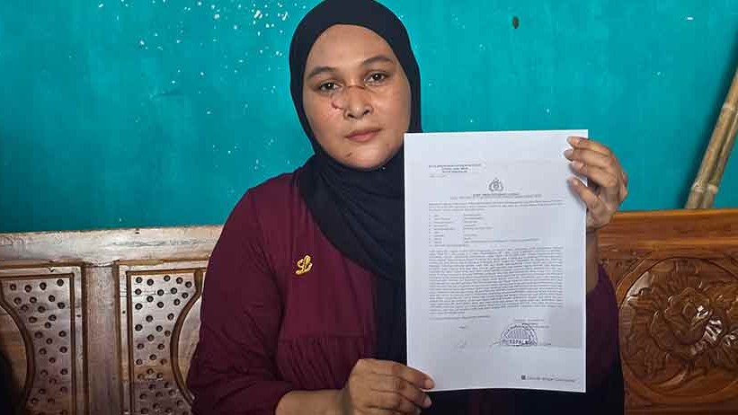 Mokarromah menunjukkan surat yang ia terima setelah melapor ke Polres Bangkalan. 
