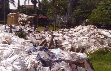 Para pekerja saat memindahi sampah ke bak truk yang akan pindahkan ke gudang SDN Janti, Kecamatan Wates, Kabupaten Kediri. (foto: arif kurniawan/BANGSAONLINE)