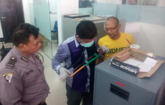 Polisi memeriksa gergaji milik pelaku pencurian yang tertinggal. 