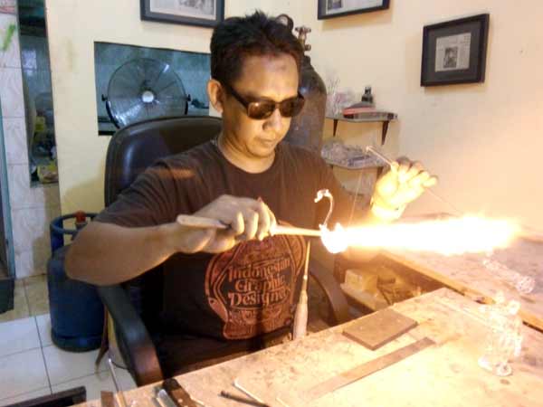 Andi sedang memraktikkan membuat seekor angsa dari kaca pyrex. foto: faratiti dewi/ BANGSAONLINE
