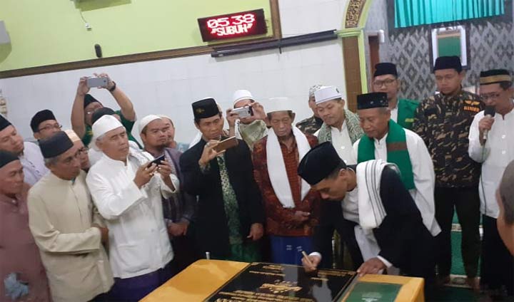 Ketua PCNU Kota Surabaya KH. Dr. Ahmad Muhibbin Zuhri menandatangani prasasti maklumat Masjid Abu Adenan sebagai masjid yang berpedoman pada amaliah, ubudiyah, dan iktiqadiyah Aswaja An Nahdliyah. foto: DIDI ROSADI/ BANGSAONLINE