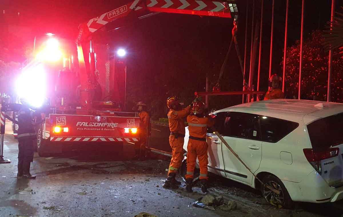 Petugas saat mengevakuasi kendaraan yang terlibat kecelakaan tunggal di Jalan Manyar Kertoarjo, Surabaya.