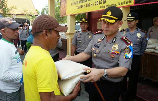 TERIMA - Salah satu abang becak yang biasa mangkal di seputaran kota menerima zakat fitrah dari Kapolres Bojonegoro, AKBP Hendri Fiuser. Foto: eky nurhadi/BANGSAONLINE