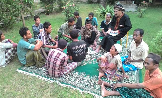 Abah Choir (pakai jubah hitam) saat memberikan tausiyah pada santrinya, yang mayoritas orang-orang gila. foto: EKY NURHADI/ BANGSAONLINE