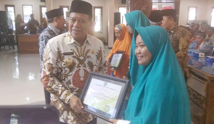 Bupati Fadeli memberikan piagam pada CJH termuda. 