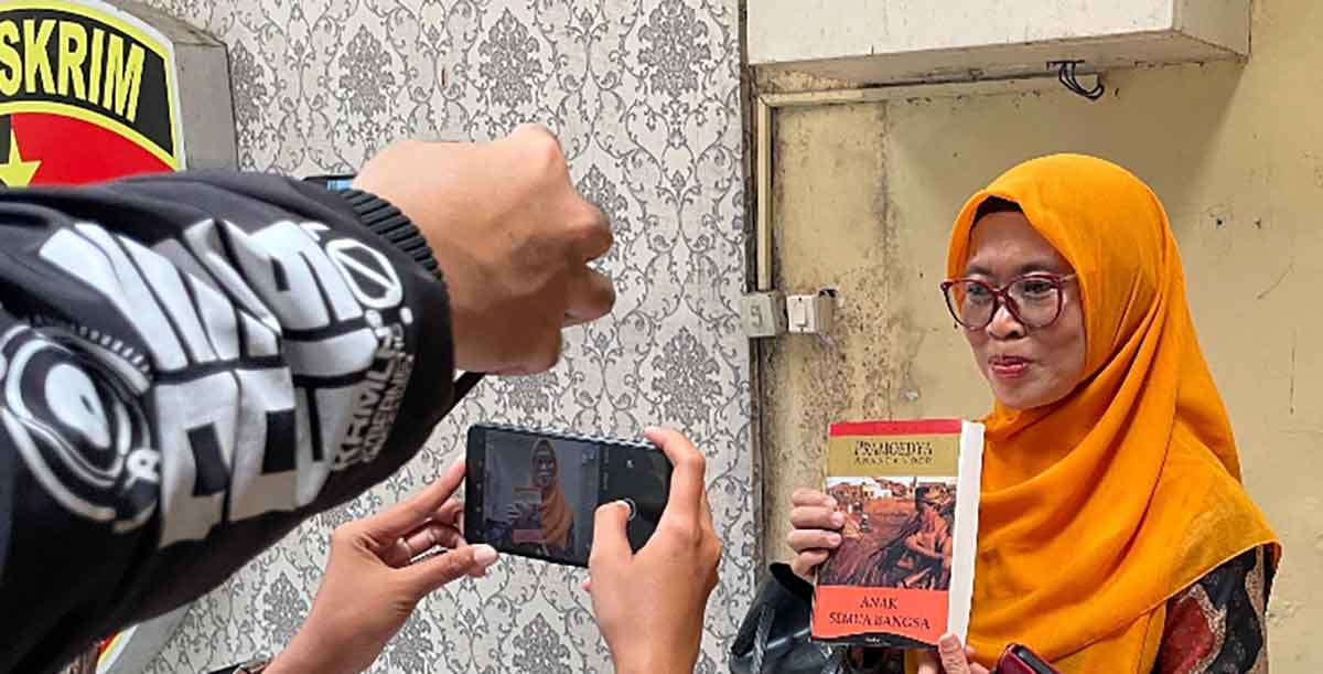 Asfinwati, ibu Faiz saat menunjukkan sebuah buku kepada wartawan. Foto: Ist
