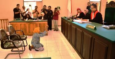 BERSIMBAH LUTUT - Nenek Asyani berlutut memohon ampunan kepada majelis hakim karena tidak terima replik JPU. (Hadi Prayitno/BANGSAONLINE)