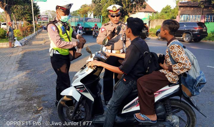 Kanit Turjawali Iptu Puji Yanto dan salah satu anggota Satlantas polres Pasuruan saat menilang pengendara motor yang tidak memakai Helm. Operasi digelar di Jalan Malang - Surabaya, tepatnya di depan Pasar Wisata Cheng Hoo, Pandaan, Sabtu (27/07/2019) sore. foto: ANDY F/ BANGSAONLINE